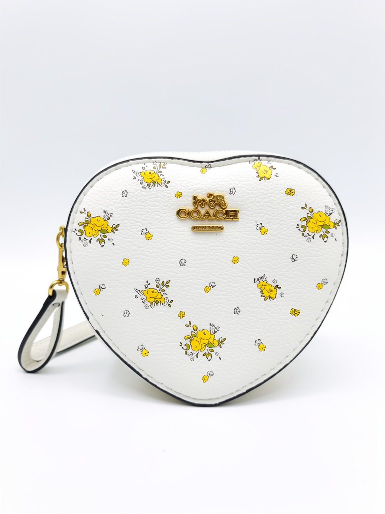 CARTERA/MUÑEQUERA COACH BLANCA CORAZON ESTAMPADO AMARILLO
