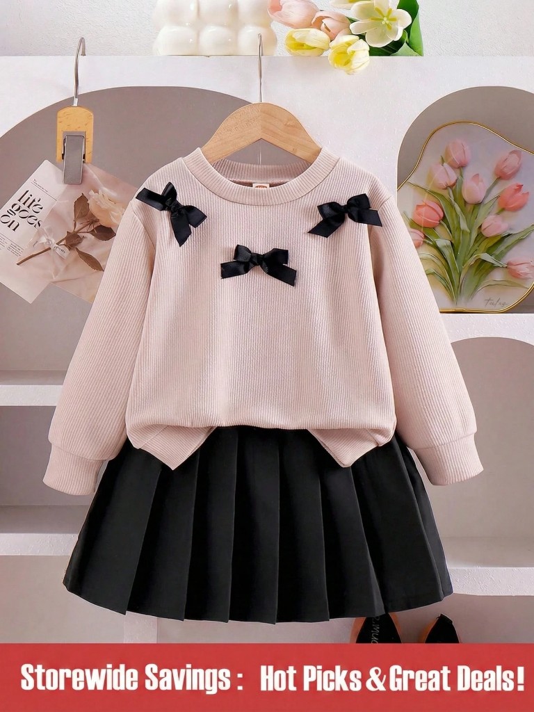 Conjunto de Falda negra plisada y Suéter rosa claro con Lazos negros