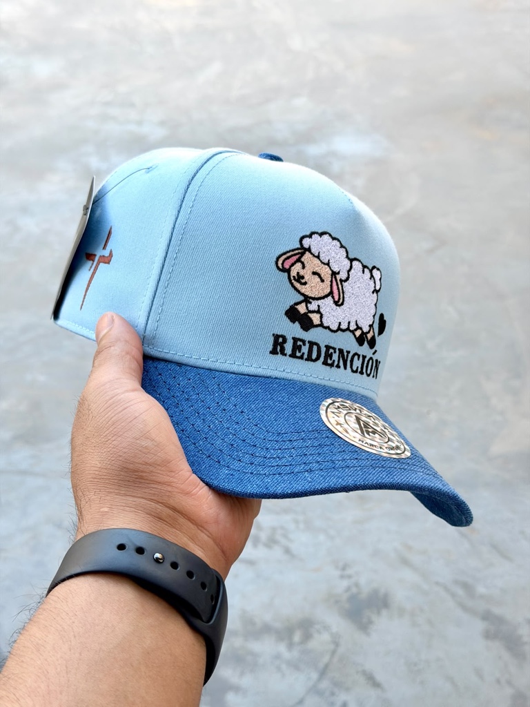 Gorra azul con bordado de oveja y texto REDENCION