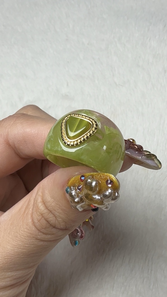 Anillo de acrílico color verde con corazón.