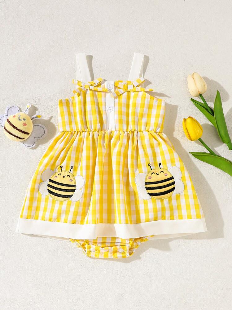 Este vestido body de bebé niña presenta un diseño a cuadros amarillos y blancos con apliques de abejas en los bolsillos