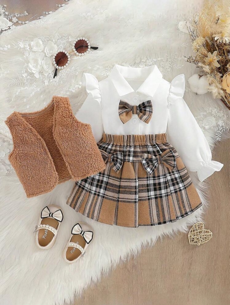 Conjunto de 3 piezas para niñas bebé que incluye: Camisa de manga larga con cuello vuelto y volantes de unicolor, falda con decoración de lazo a cuadros, y chaleco esponjoso.
