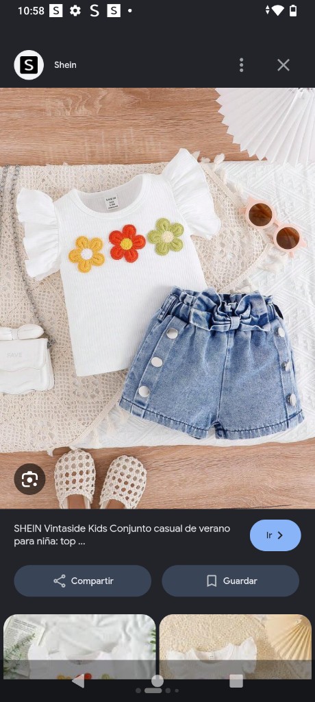 Este es un conjunto de verano para niña Vintaside Kids que incluye un top blanco acanalado con flores 3D y shorts de mezclilla.