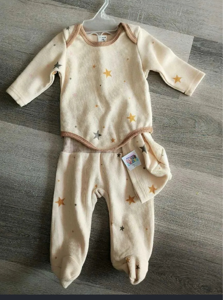 conjunto de bebé de color beige con estampado de estrellas y cuello marrón.
