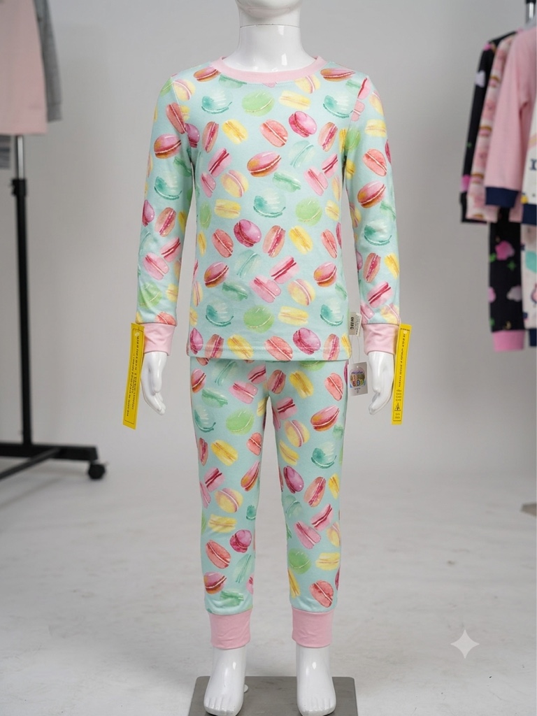 Este conjunto de pijama para niñas de SHEIN presenta un estampado colorido de macarons sobre un fondo verde menta y detalles en rosa.