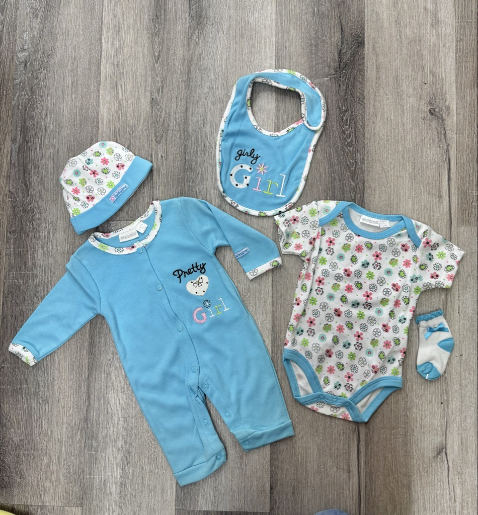 Este conjunto de ropa para bebé de estilo similar presenta estampados florales y detalles bordados en colores pastel.