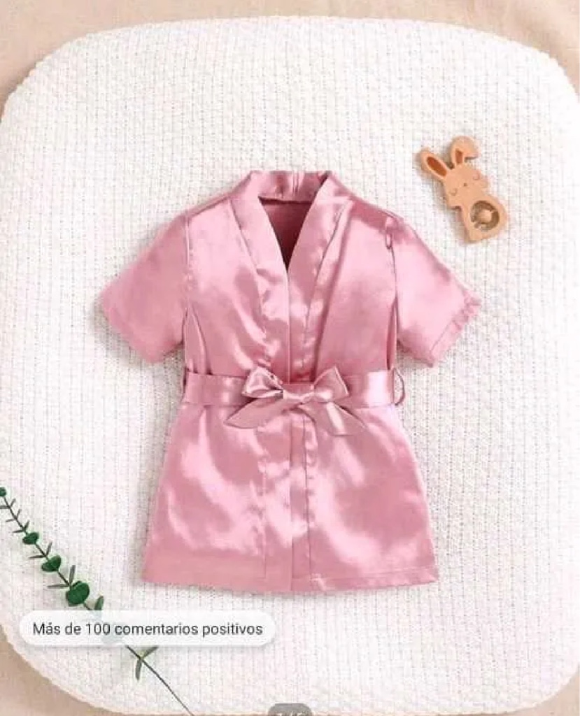 Esta bata de satén color rosa pálido cuenta con un cinturón a juego para un ajuste estilizado.