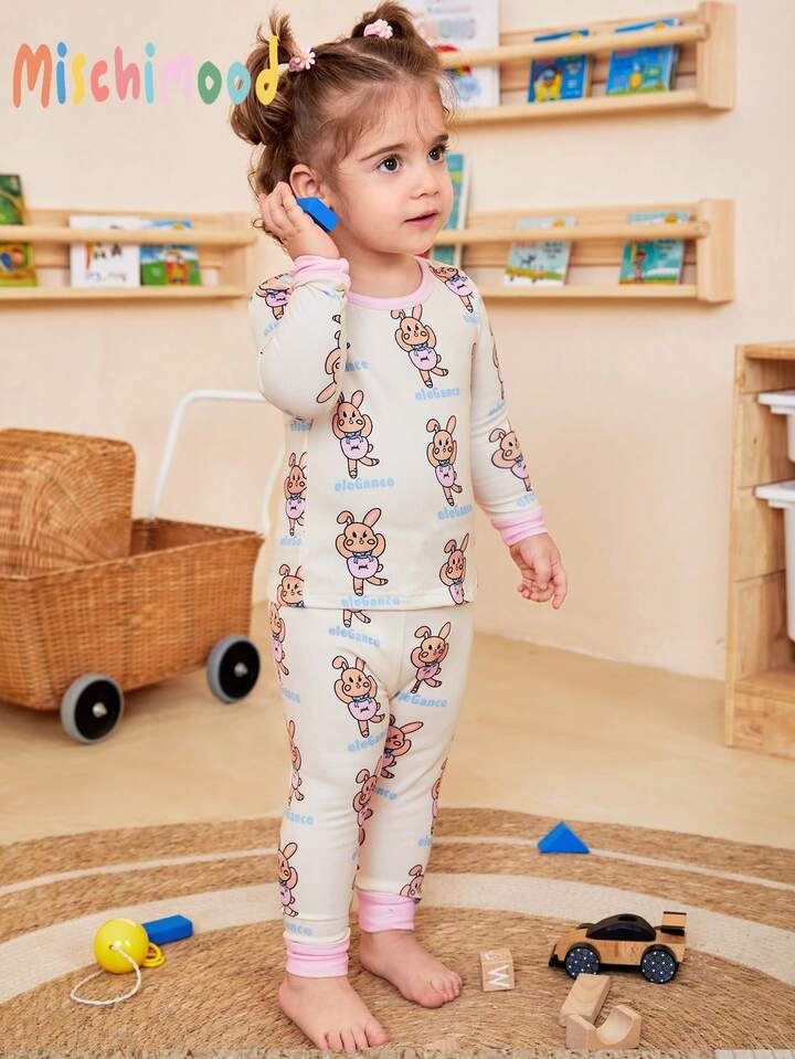 Este conjunto de pijama de dos piezas de SHEIN presenta un estampado de conejitos color albaricoque con detalles en rosa.
