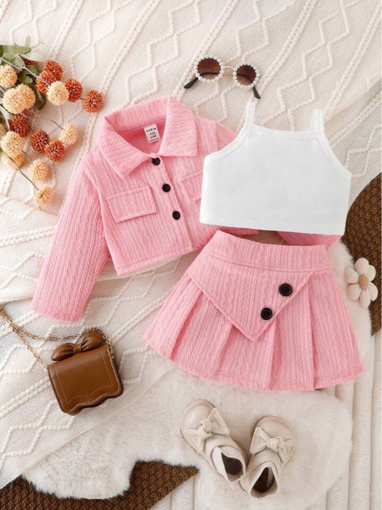 Este conjunto de tres piezas para niña incluye una chaqueta rosa con botones, un top blanco y una falda plisada a juego.