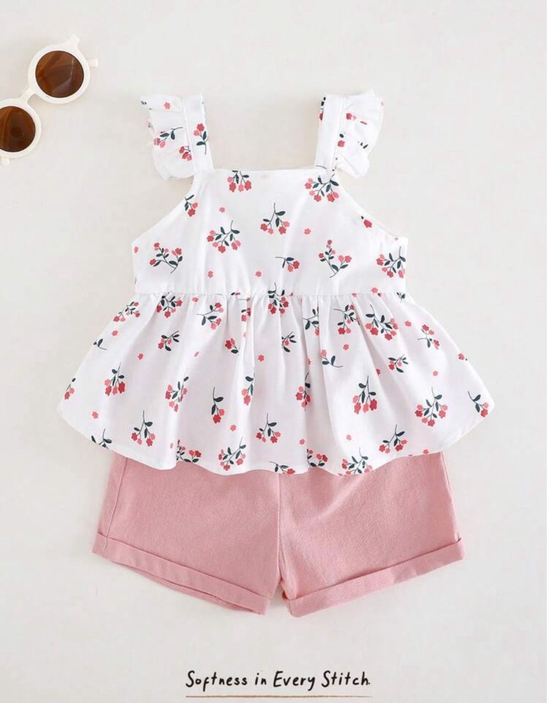 Este conjunto de bebé niña de 2 piezas presenta una blusa blanca sin mangas con tirantes de volantes y estampado floral, combinada con shorts rosados con vuelta en el dobladillo.