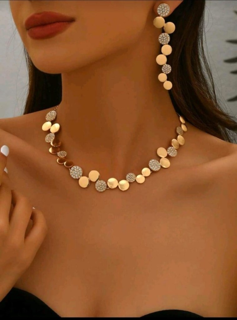 Gargantilla dorada con strass y aros largos. Caja de pana