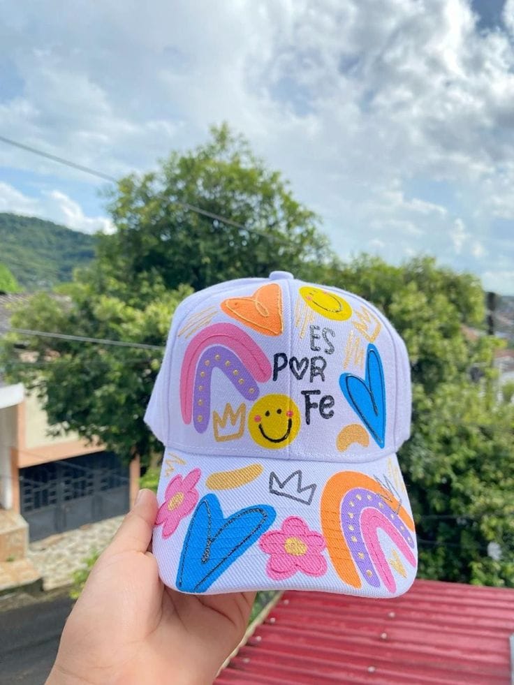 Gorra blanca decorada con mensaje 'Es por Fe'