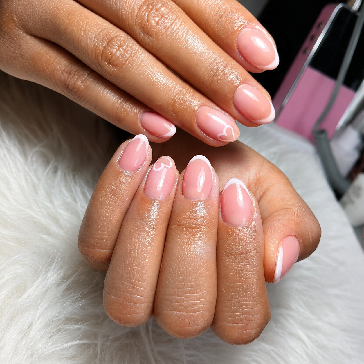 Manicura en uñas cortas con base rubber rosadas con diseño blanco