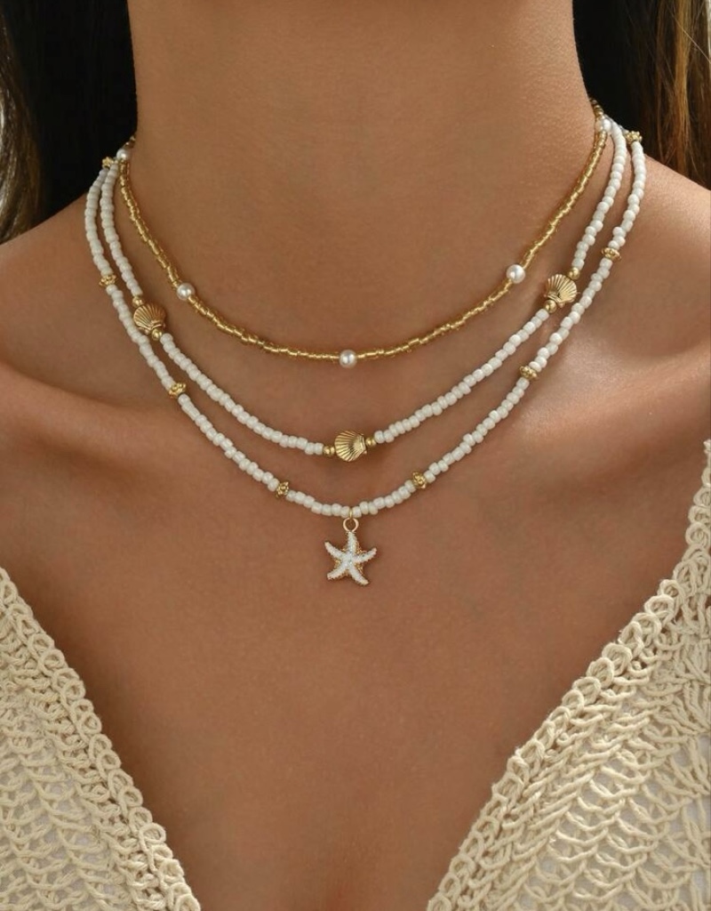 Collar blanco y dorado con dije estrella