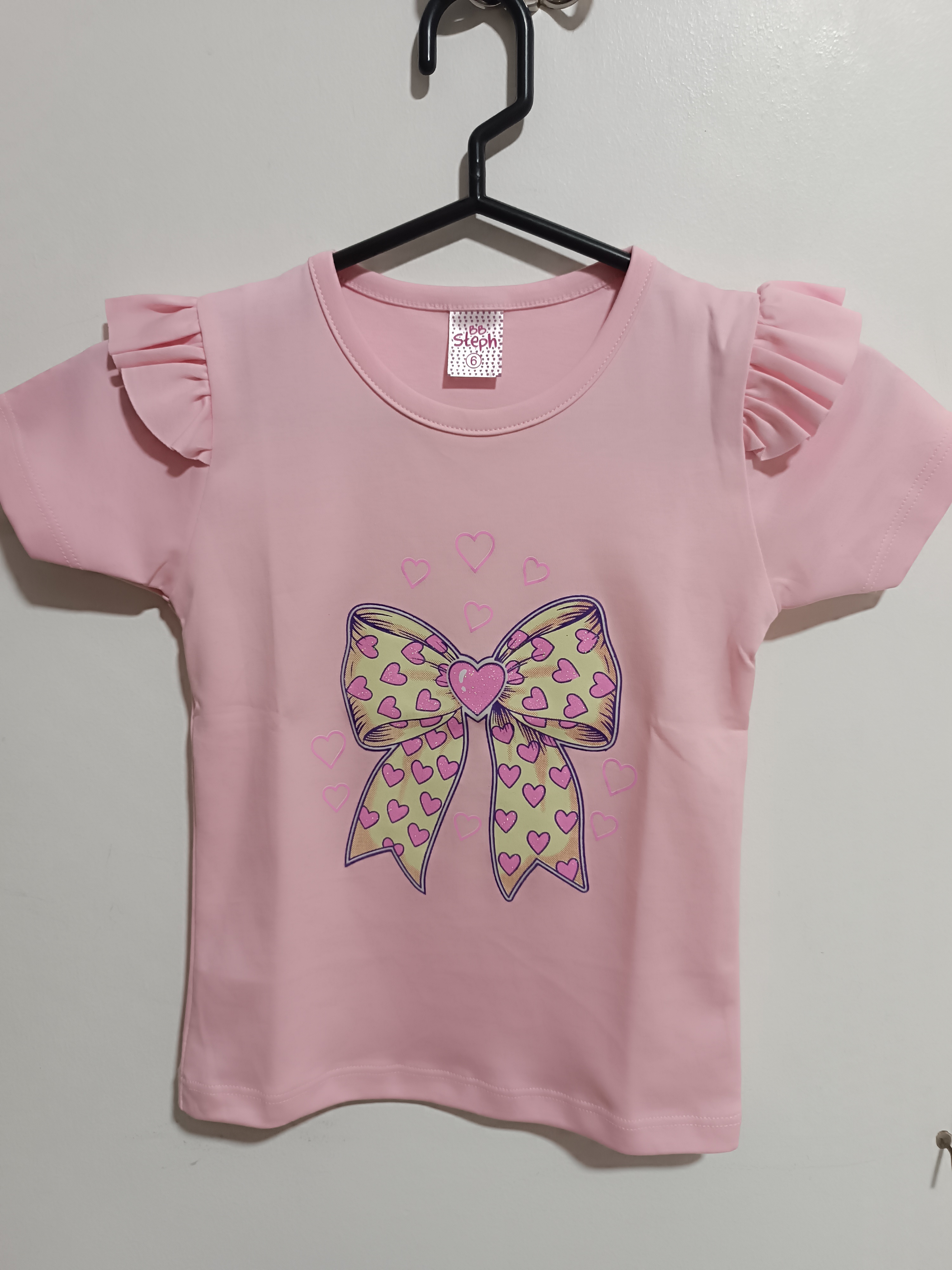 Camiseta infantil rosada con lazo y corazones