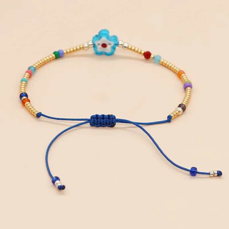 Pulsera de hilo azul con cuentas y flor roja