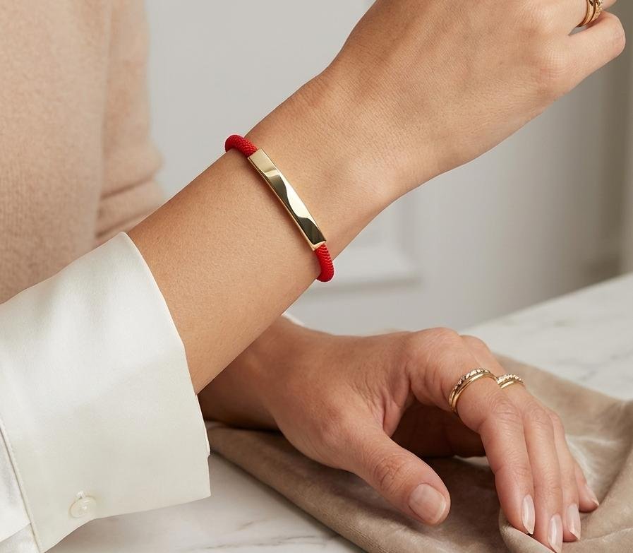 pulsera de cordon rojo con plaquita dorada