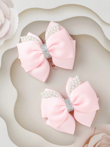 Par de lazos en cinta rosa con detalle brillante y perlas