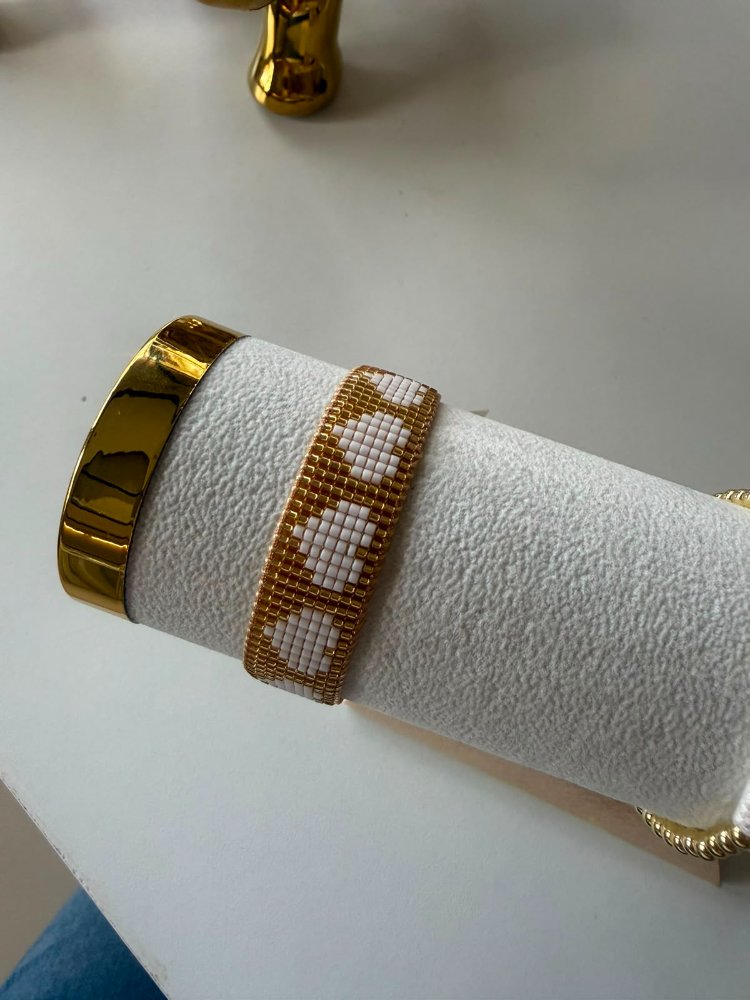 pulsera dorada con corazones blancos