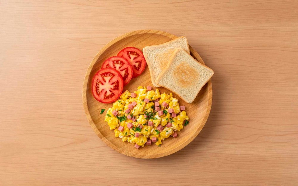 Huevos revueltos con extras de jamón, queso y tomate