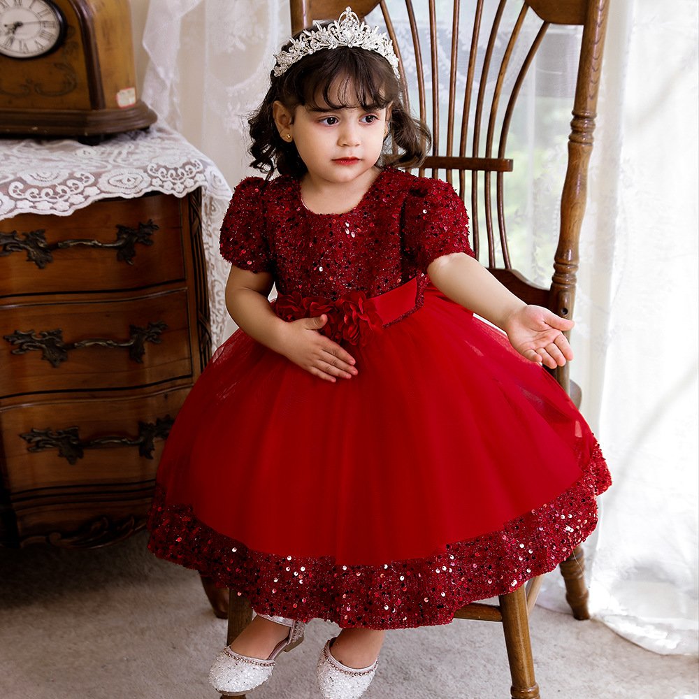 Vestido de niña, vestido rojo con parte superior con lentejuelas y franja de lentejuela en la parte inferior, ramo de flores en la cintura