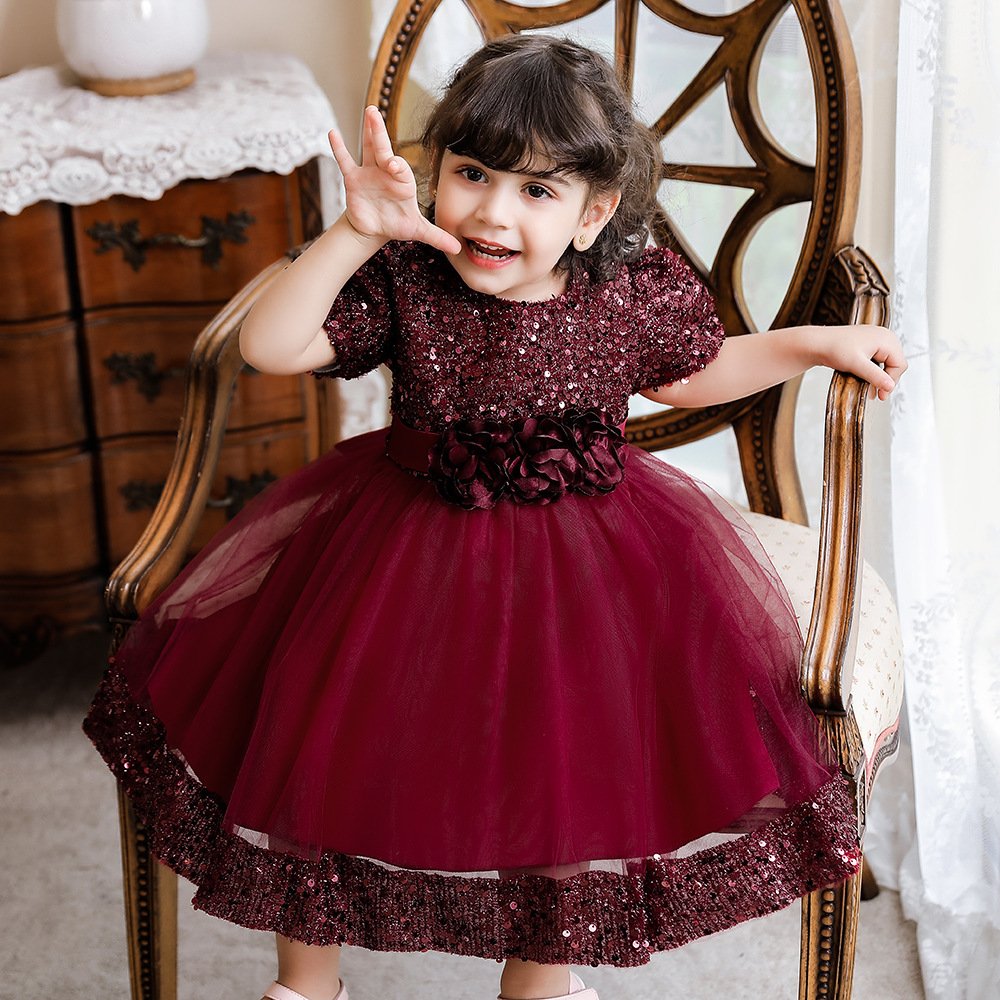 Vestido de niña, vestido rojo vino con parte superior con lentejuelas y franja de lentejuela en la parte inferior, ramo de flores en la cintura
