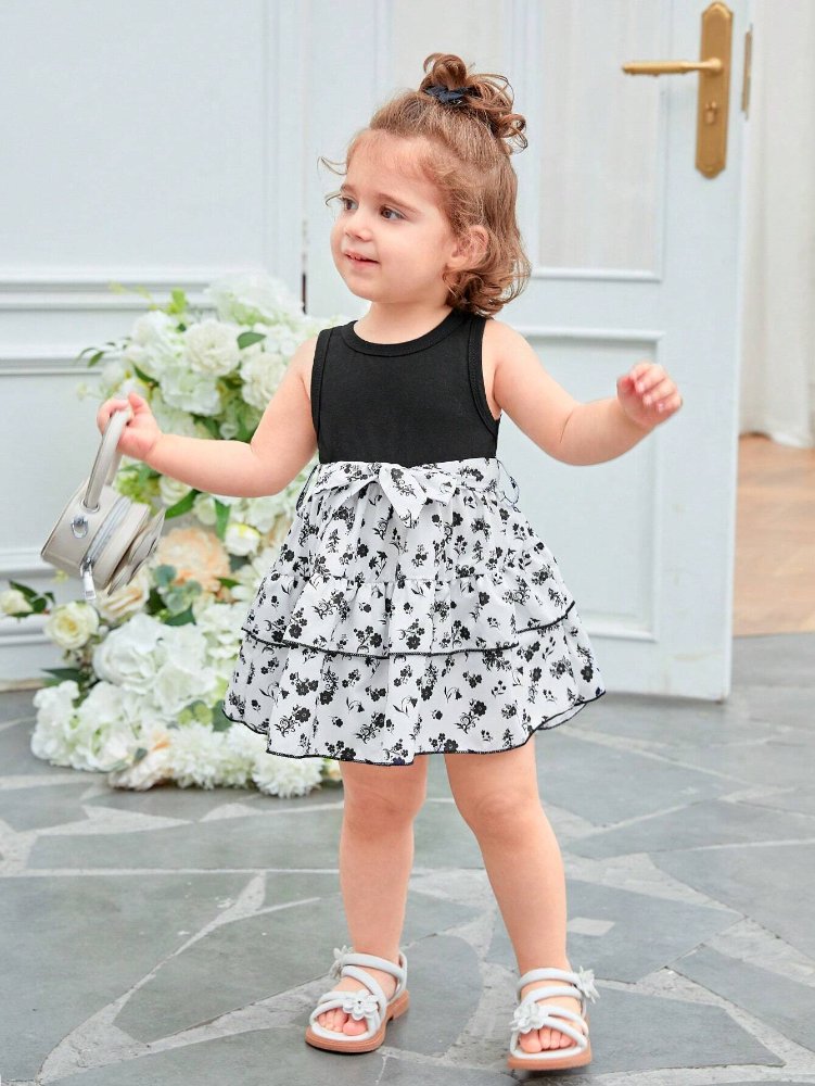 Vestido de niña, vestido negro en la parte de arriba y parte de abajo blanca con flores color negro de vuelos