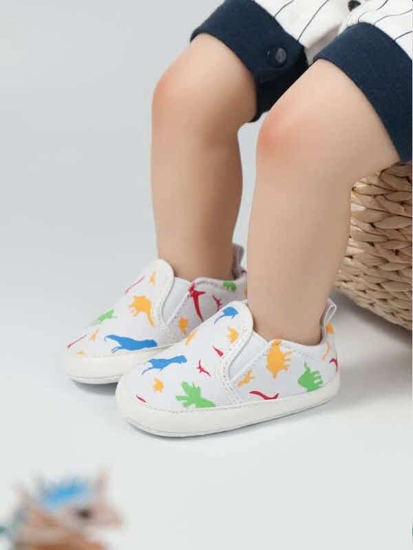 Zapatitos blancos con dibujos de dinosaurio