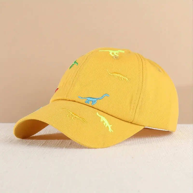 Gorra para niño color amarillo con dibujos de dinosaurios