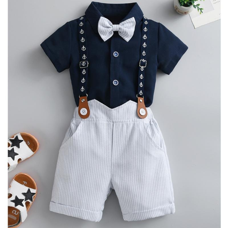 Traje de niño, traje de short y corbatín blanco con rayas gris, camisa azul manga corta y tirante azul con figuras de anglas