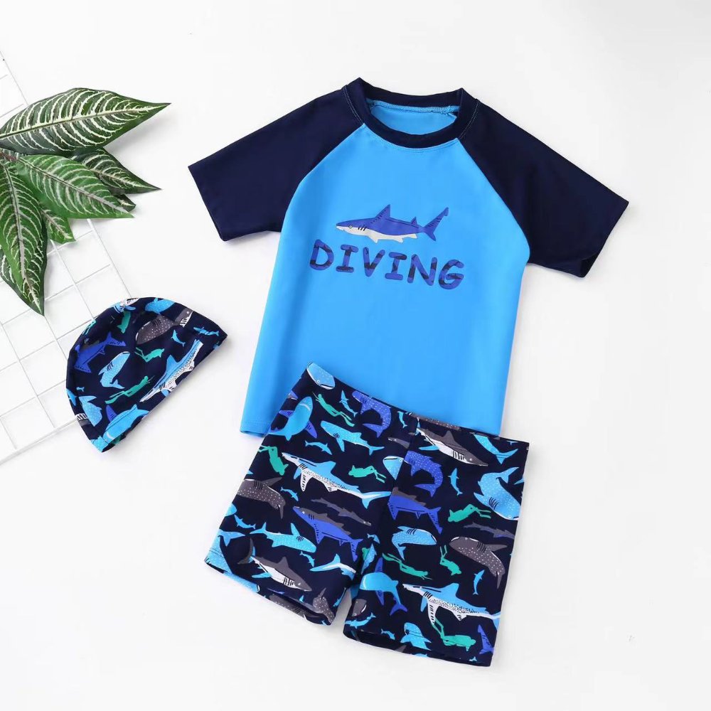 Traje de baño de niño, celeste con mangas cortas en azul short y gorro con dibujos de tiburones manga corta y short